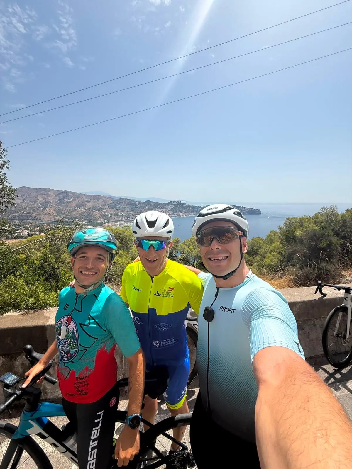 Manu con sus dos compañeros durante la salida en bicicleta del domingo, con la costa al fondo