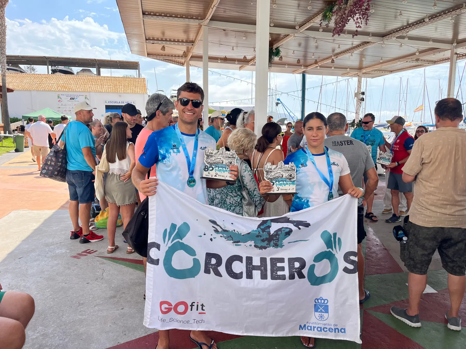 Sergio y Mari con sus trofeos y la bandera del club