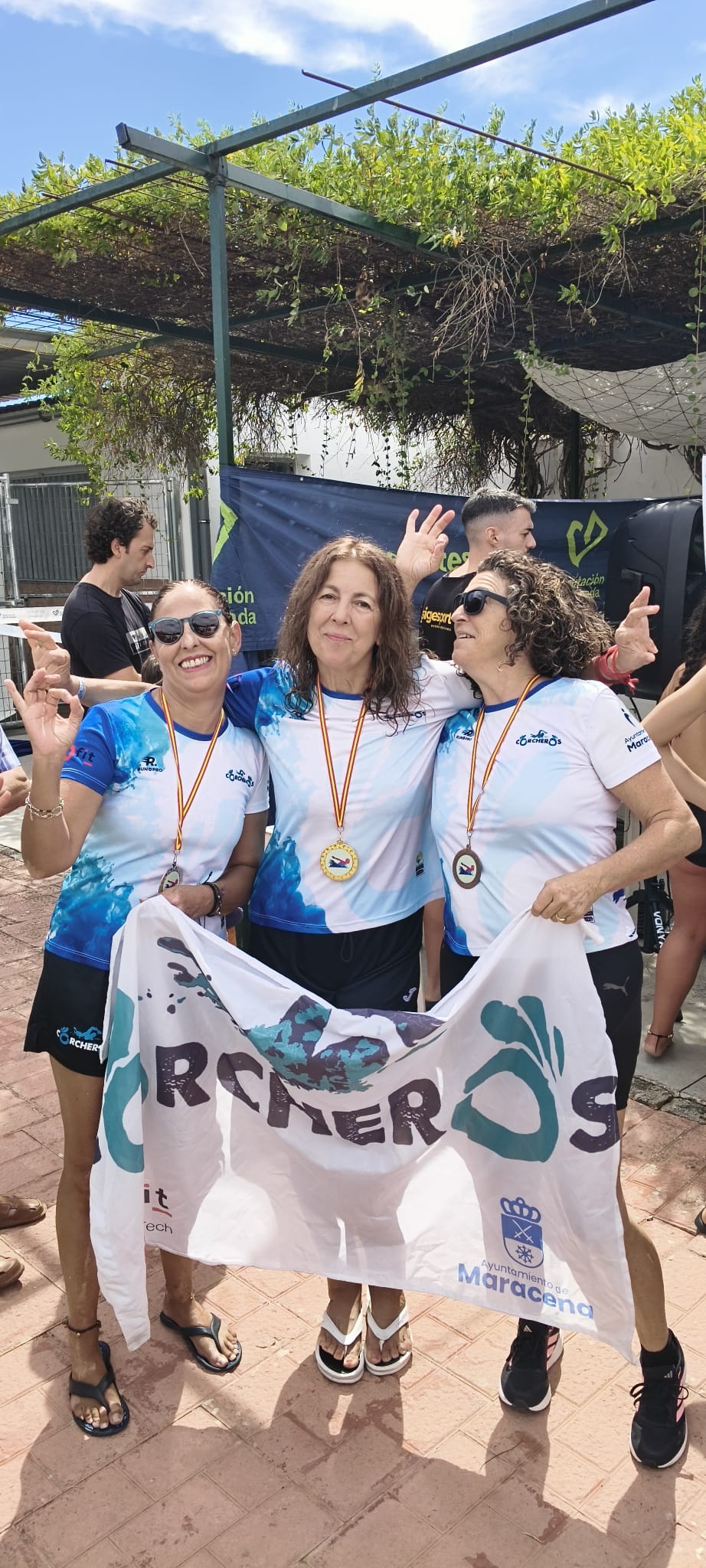 Tres Corcheras luciendo sus medallas y la bandera del club