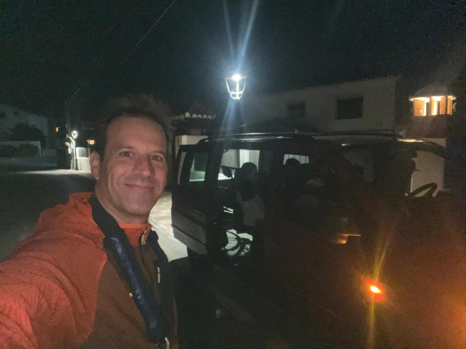 Participante junto a su vehículo antes de la salida nocturna hacia la prueba